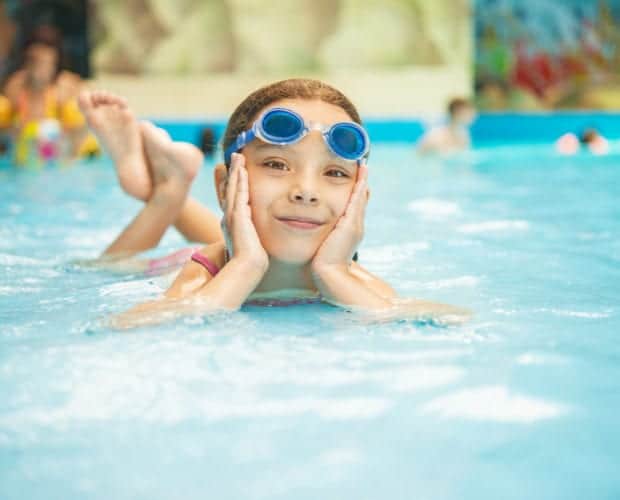 smiling little girl enjoying indoor pool at Oak Tree Lodge