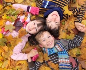 Kids playing in the autumn leaves