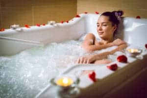 Woman relaxing in the tub at a Pigeon Forge hotel Jacuzzi suite.