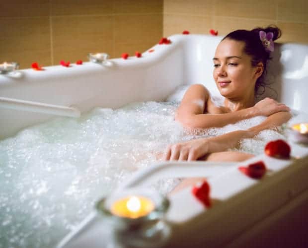 Woman relaxing in the tub at a Pigeon Forge hotel Jacuzzi suite.