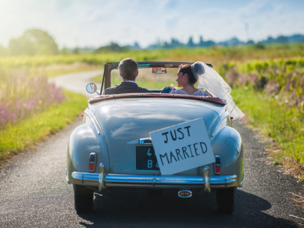 newlywed couple driving off