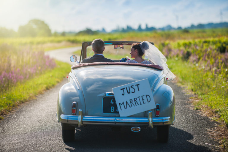newlywed couple driving off